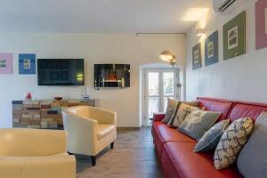 - un salon avec un canapé rouge et une chaise dans l'établissement Relais AL Porto SUITE PELER, à Peschiera del Garda