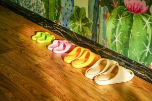 a group of four pairs of shoes on a wooden floor at Wind sleeping Color Hotel - Line7&18Nancun Wanbo STN in Guangzhou