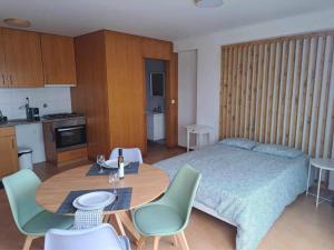 a bedroom with a bed and a table and chairs at Estúdio Frente Mar in Horta