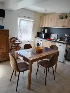 uma cozinha com uma mesa de madeira e cadeiras numa cozinha em maison ancienne em Louviers