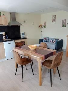 a dining room table with chairs and a kitchen at maison ancienne in Louviers