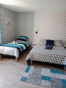 1 dormitorio con 2 camas y alfombra en maison ancienne en Louviers