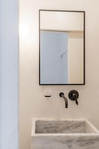 a bathroom with a sink and a mirror at aníko suites White Alley in Mýkonos City
