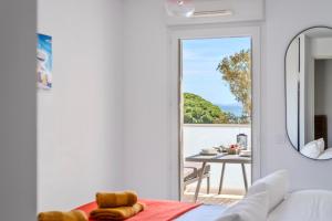 a bedroom with a door leading to a patio with a table at Appartement Vue Mer 50m plage des Salins Piscine 2 parkings Terrasse in Hyères