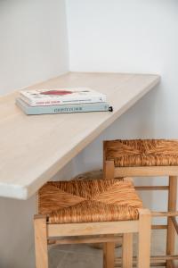 a table with two books and a chair at aníko suites White Alley in Mýkonos City