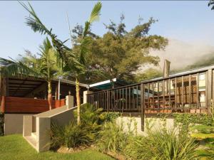 a house with palm trees in front of it at Port St Johns River Lodge in Port St. Johns