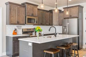 a kitchen with wooden cabinets and a kitchen island with stools at Zion's Paradise townhouse in Hurricane