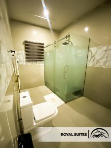 a bathroom with a toilet and a glass shower at LA GRANITA HOTEL AND SUITES in Ado Ekiti