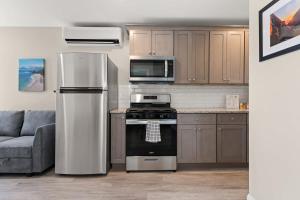 a kitchen with a refrigerator and a stove and a couch at Fully Renovated - Sleeps 6 - Walk to Beach in Hampton