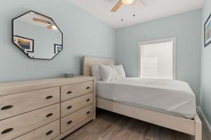 a bedroom with a bed and a dresser and a mirror at Fully Renovated - Sleeps 6 - Walk to Beach in Hampton