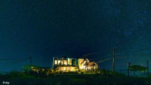 een huis wordt 's nachts verlicht met lichten bij The Forest and Lake by Schofieldshire in Nuwara Eliya