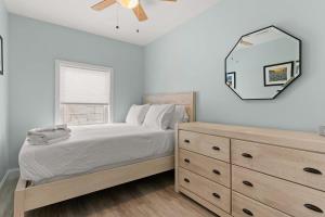 um quarto com uma cama com uma cómoda e um espelho em Fully Renovated - Walk to Beach - The Americana em Hampton