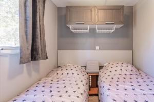 Habitación pequeña con cama y ventana en Mobil home vacances en Puget-sur Argens