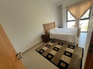 1 dormitorio con cama y ventana con alfombra en Townhouse Private Room, en Dubái