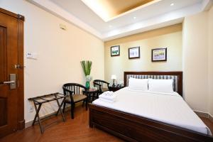 Nicecy Hotel - Bui Thi Xuan Street في مدينة هوشي منه: غرفة نوم بسرير وطاولة وكراسي