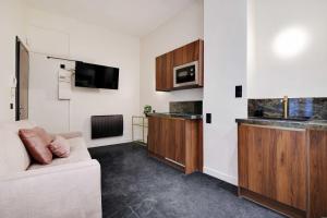 a living room with a couch and a tv at Exceptional studio Place des Vosges Marais in Paris