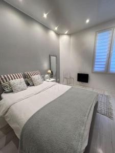 a white bedroom with a large bed and a window at Monaco chic haven Casino border in Beausoleil