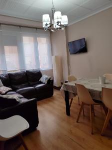 a living room with a black couch and a table at Serendipia Apartamentos 1 in Logroño