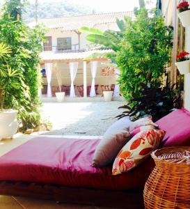 a bed with pillows sitting on a patio at Itamambuca Casa de Praia in Ubatuba