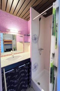 uma casa de banho com um lavatório, um espelho e uma banheira em Studio cabine avec piscine au Grau du Roi em Le Grau-du-Roi