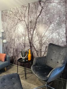 a living room with a wall mural of trees at Deluxe Apartement mit Terrasse in Duisburg