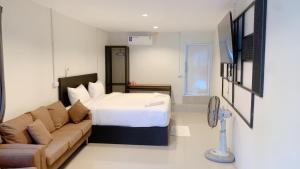 タオ島にあるAmazing Inn Koh Taoのベッドとソファ付きのホテルルーム