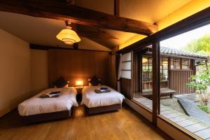 um quarto com 2 camas e uma grande janela em PAYSAGE MORIGUCHI em Mima