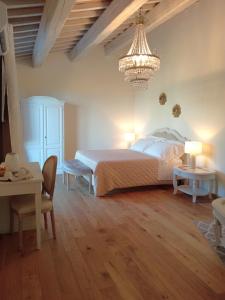 a bedroom with a large bed and a chandelier at Boutique Hotel Masolino in Panicale