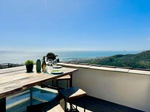 a table on a balcony with a view of the ocean at Hostdomus - Le Vigne sul Mare in Pietra Ligure +31 photos