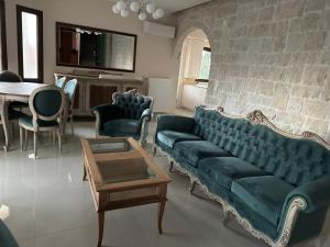 a living room with a green couch and a table at Summerhouse in Nea Karvali