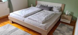 1 cama grande con sábanas blancas y almohadas. en Haus Tildchen, en Ayl