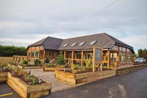 a large building with plants in front of it at Charming 1-Bed Barn Alton Towers Polar Bears Peaks in Whiston