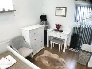 a bedroom with a white dresser and a chair and a desk at Charming 1-Bed Barn Alton Towers Polar Bears Peaks in Whiston