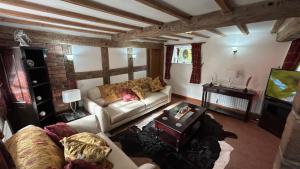 uma sala de estar com um sofá e uma televisão em Character 3-Bed Cottage Alton Towers Polars Peaks em Whiston