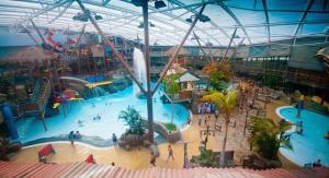 an indoor water park with a large swimming pool at Charming 1-Bed Barn Alton Towers Polar Bears Peaks in Whiston