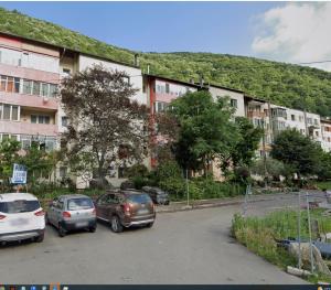a parking lot with cars parked in front of a building at Apartament 14 in Băile Herculane