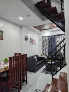a living room with a couch and a staircase at Kings'Palms Residence01 in General Santos
