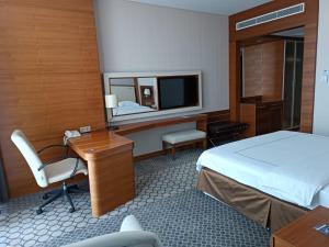 a hotel room with a bed and a desk and a mirror at Anemon Samsun Hotel in Samsun