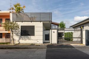 een wit huis met een hek en een hek bij Suite Casa dell'Eden vicino F1/San Gerardo/Monza in Lissone