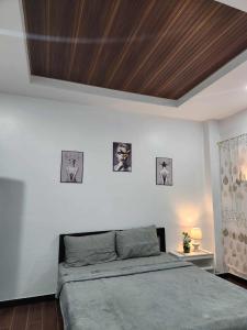 a bedroom with a bed with a wooden ceiling at Kings'Palms Residence01 in General Santos