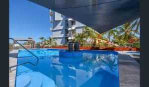 a swimming pool at a hotel with a building at Cullen Bay Resorts in Darwin