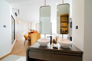a bathroom with two sinks on a counter with a mirror at PĀMA Boutique Hotel & Bistro in Da Nang