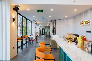 a bar in a restaurant with orange chairs at PĀMA Boutique Hotel & Bistro in Danang