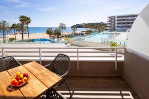 a table with a bowl of fruit on a balcony with the beach at My Sea view - Magaluf in Magaluf