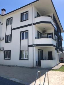 een wit appartementencomplex met zwarte ramen bij Dalaman Apart Vacance , Ozgün Deniz Sitesi No 5 in Dalaman