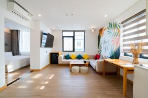 a living room with a couch and a table at PĀMA Boutique Hotel & Bistro in Da Nang