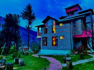Una casa en las montañas por la noche en Nature Valley Resort Manali 2 Bedrooms luxury Cottages, en Manali