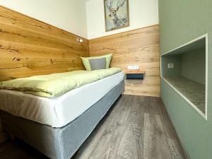 a bedroom with a bed with a wooden wall at Hotel Waldberg in Stolberg