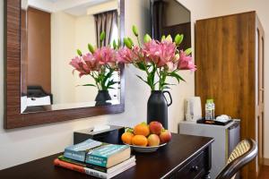 a table with a bowl of fruit and flowers in a hotel room at Nicecy Hotel - Bui Thi Xuan Street in Ho Chi Minh City