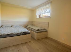 two twin beds in a bedroom with a window at Apartament Pod Malinka in Wisła